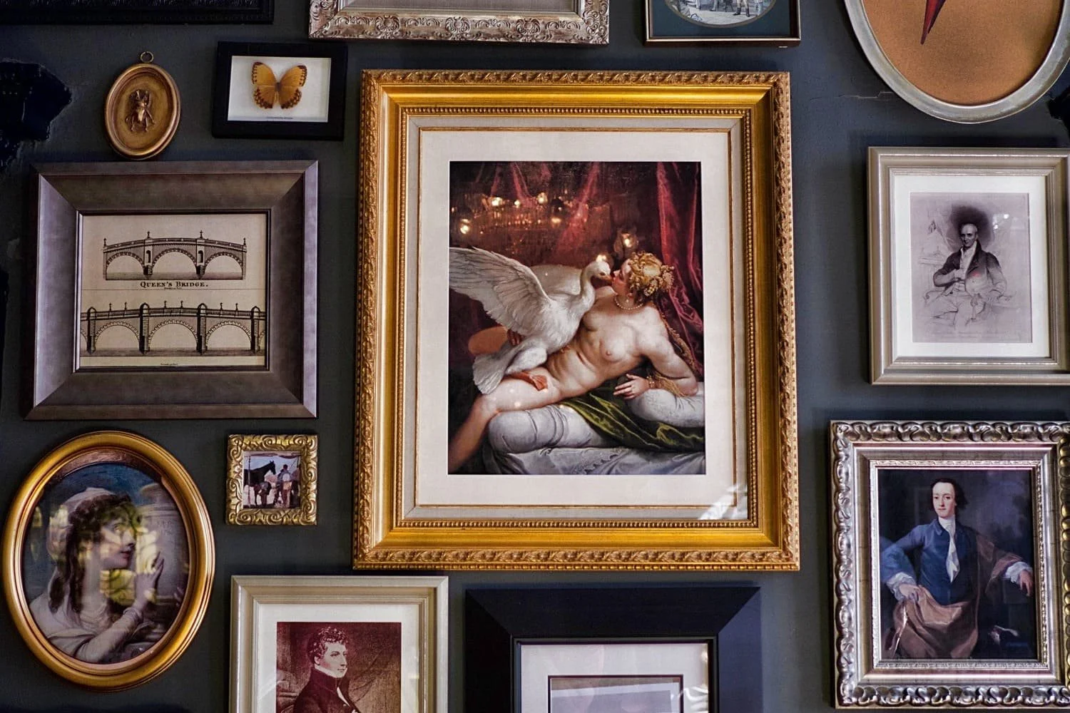 A wall of framed paintings